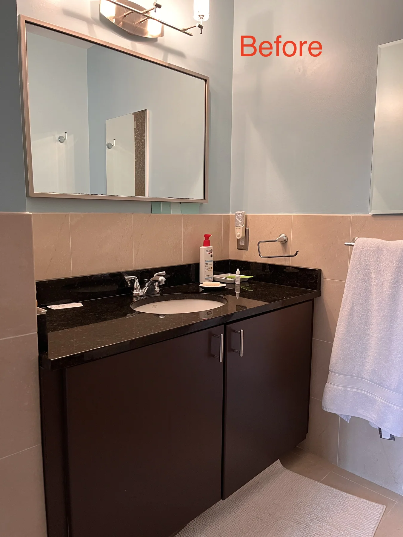 Original bathroom vanity with dark cabinetry before renovation